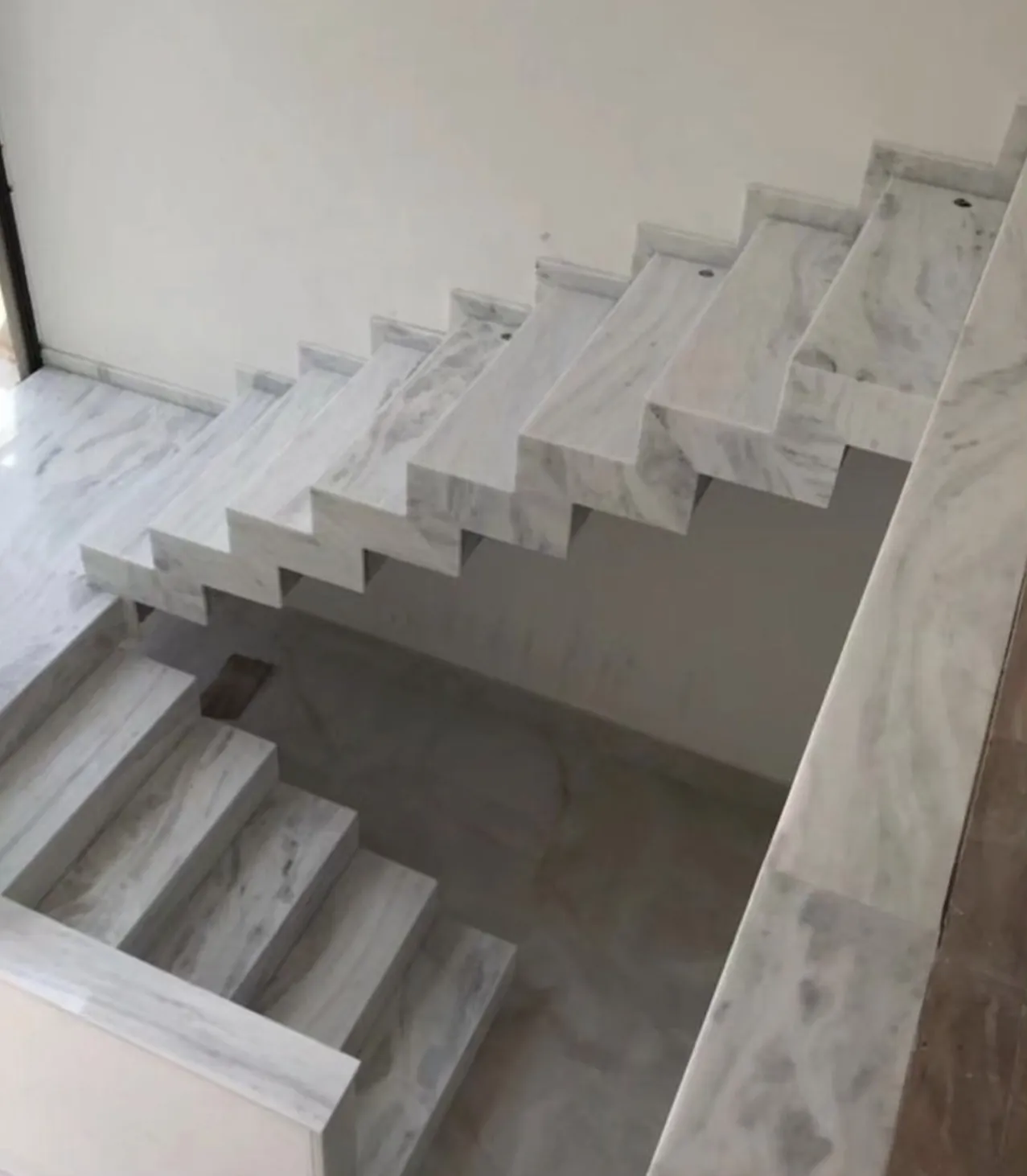 Revestimento de escada em pedra natural: Escada em mármore branco com lateral recortada