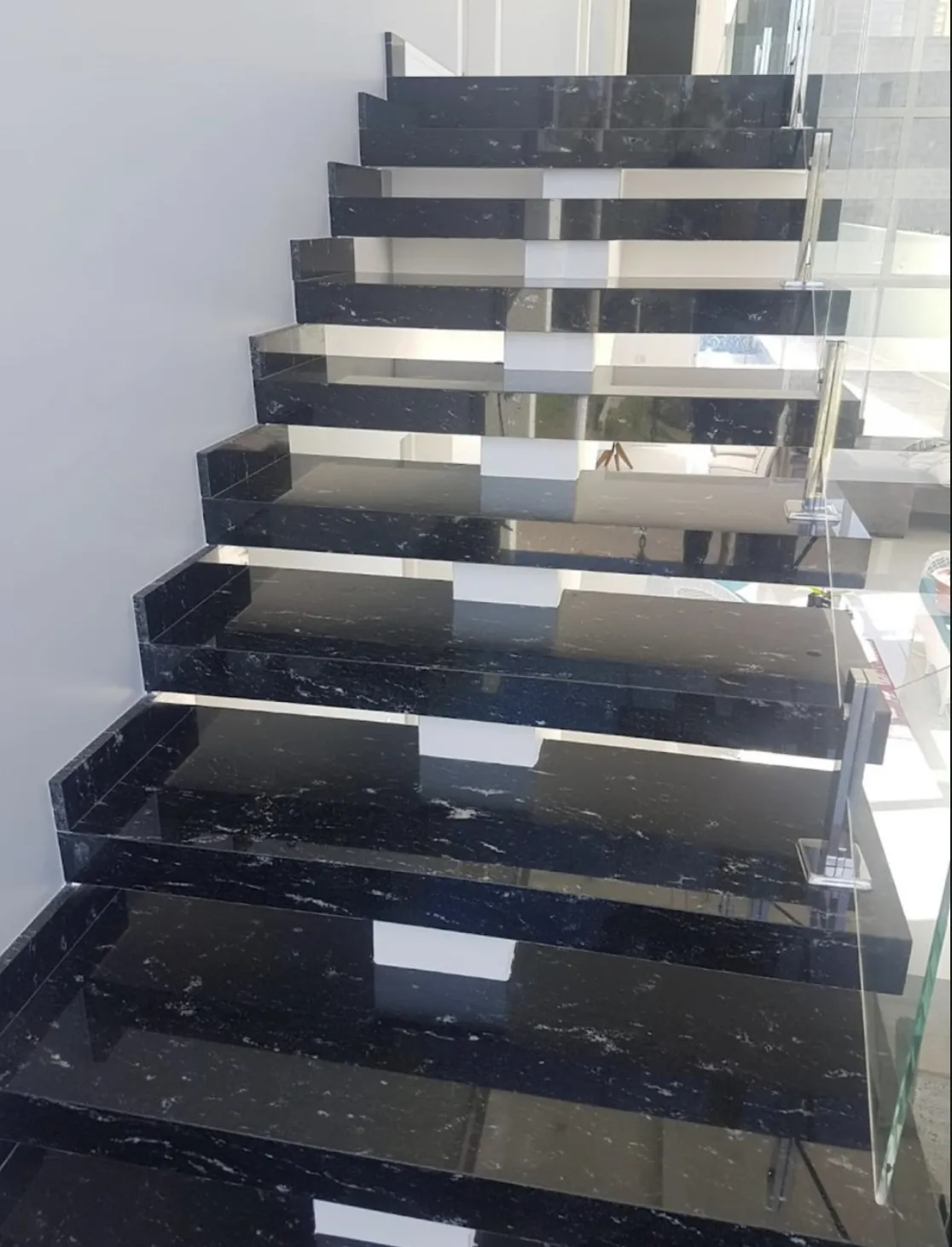 Revestimento de escada em pedra natural: Degraus em granito preto com veios brancos