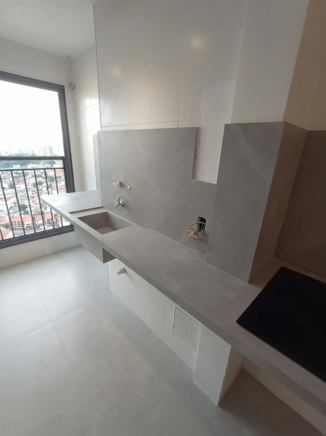 Apartamento em lâmina cinza em pedra natural: Bancada longa junto à janela